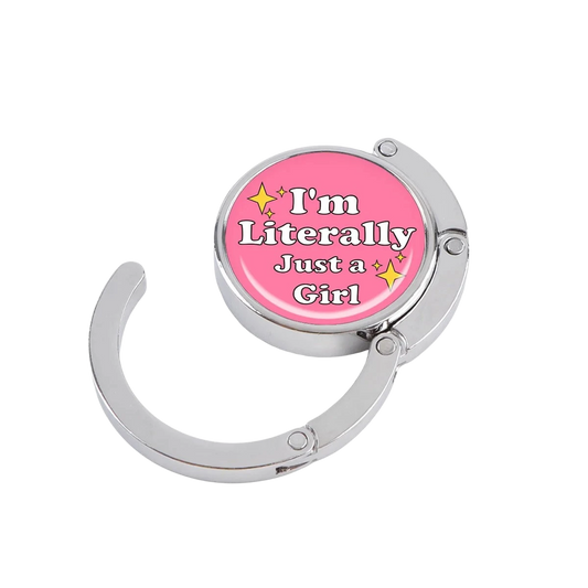 NOOX Just a Girl foldable metal bag hanger in pink with a white text design and yellow star accents